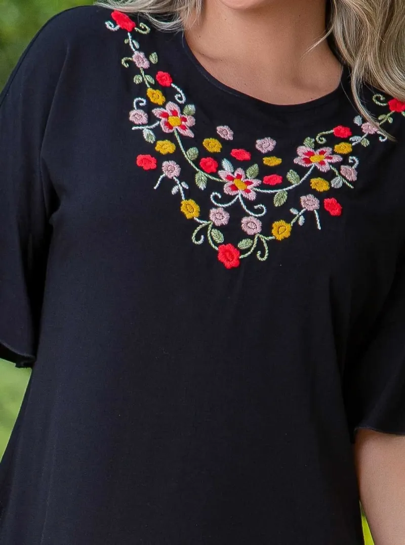 Blusa con flores bordadas a mano por artesanas de Cartago